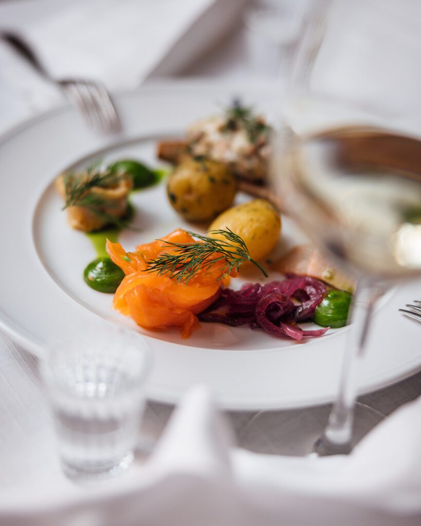 Kalalautanen, jossa graavattua lohta, skagenröraa, mustaherukka- ja fenkolisilakoita ja keitettyjä perunoita