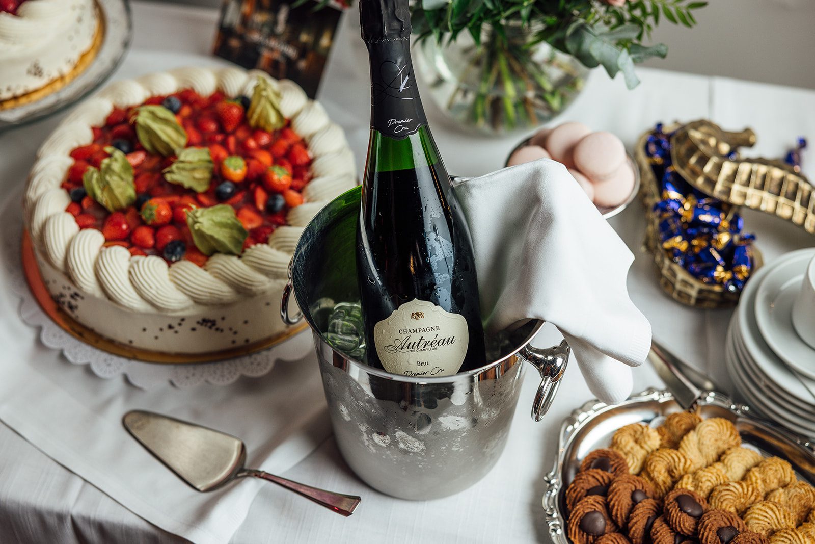 Juhlatilaisuuksien kakkupöytä, mansikkatäytekakku, pikkuleipiä, konvehteja ja samppanjaa klassisessa Ravintola Sea Horsessa Helsingin Ullanlinnassa Festive dessert table with strawberry cake, biscuits, chocolates and champagne at classic restaurant Sea Horse, Ullanlinna, Helsinki